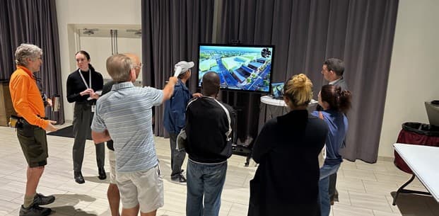 Residents gathered around a large screen showing the digital twin at the Community Open House